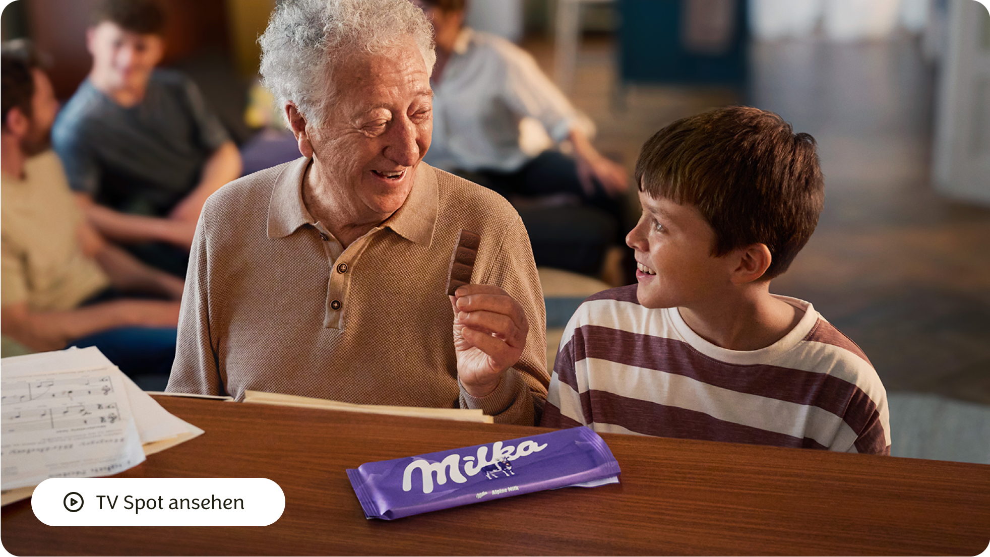 Eine Frau spricht mit einem Junge der ein MILKA Produkt hat